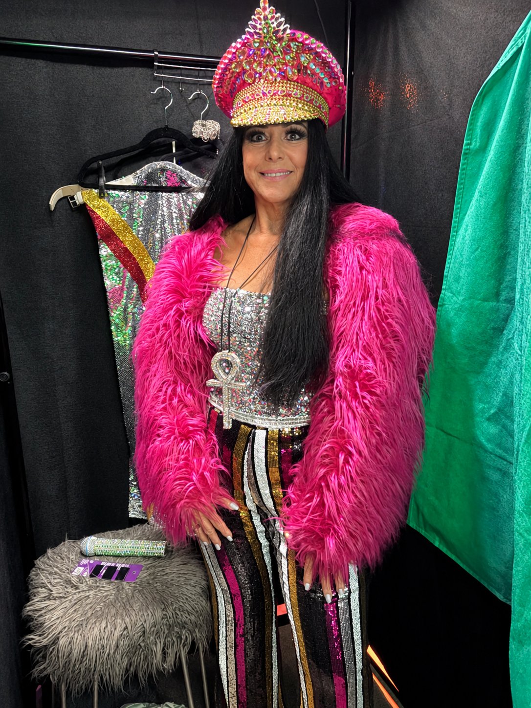 Cher Alike in a pink faux-fur coat and rhinestone captain's hat
