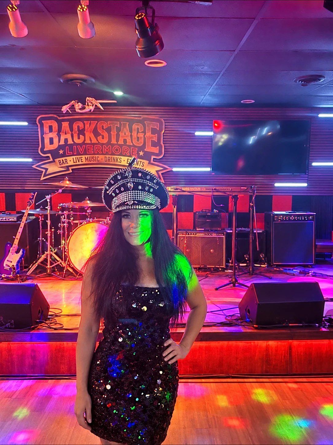 Cher Alike in a black sequin dress and rhinestone captain's hat at Backstage Livermore